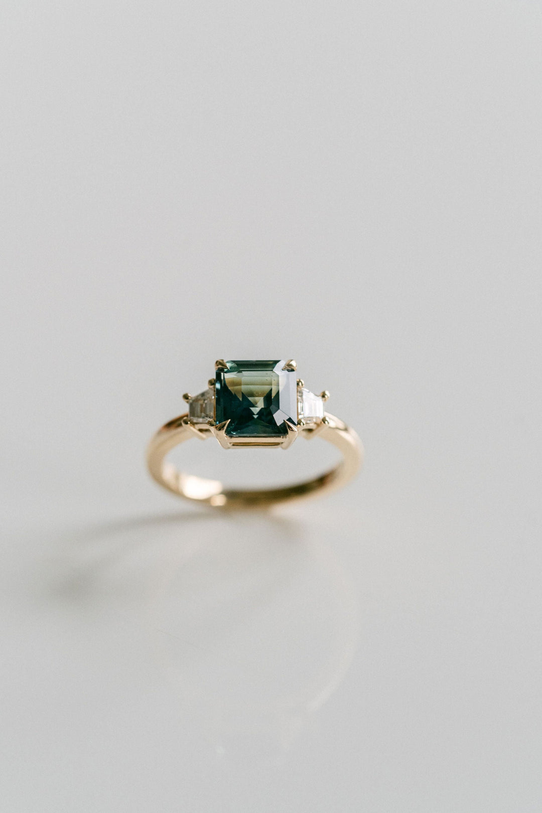 Square Emerald Cut Blue-Green Sapphire with Step Cut Trapezoid Diamond Accents