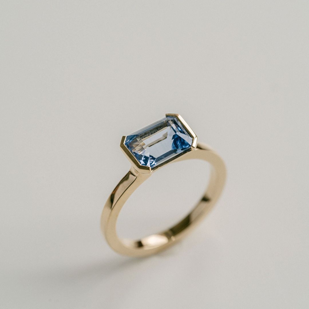 Emerald Cut Blue Sapphire East-West Half Bezel