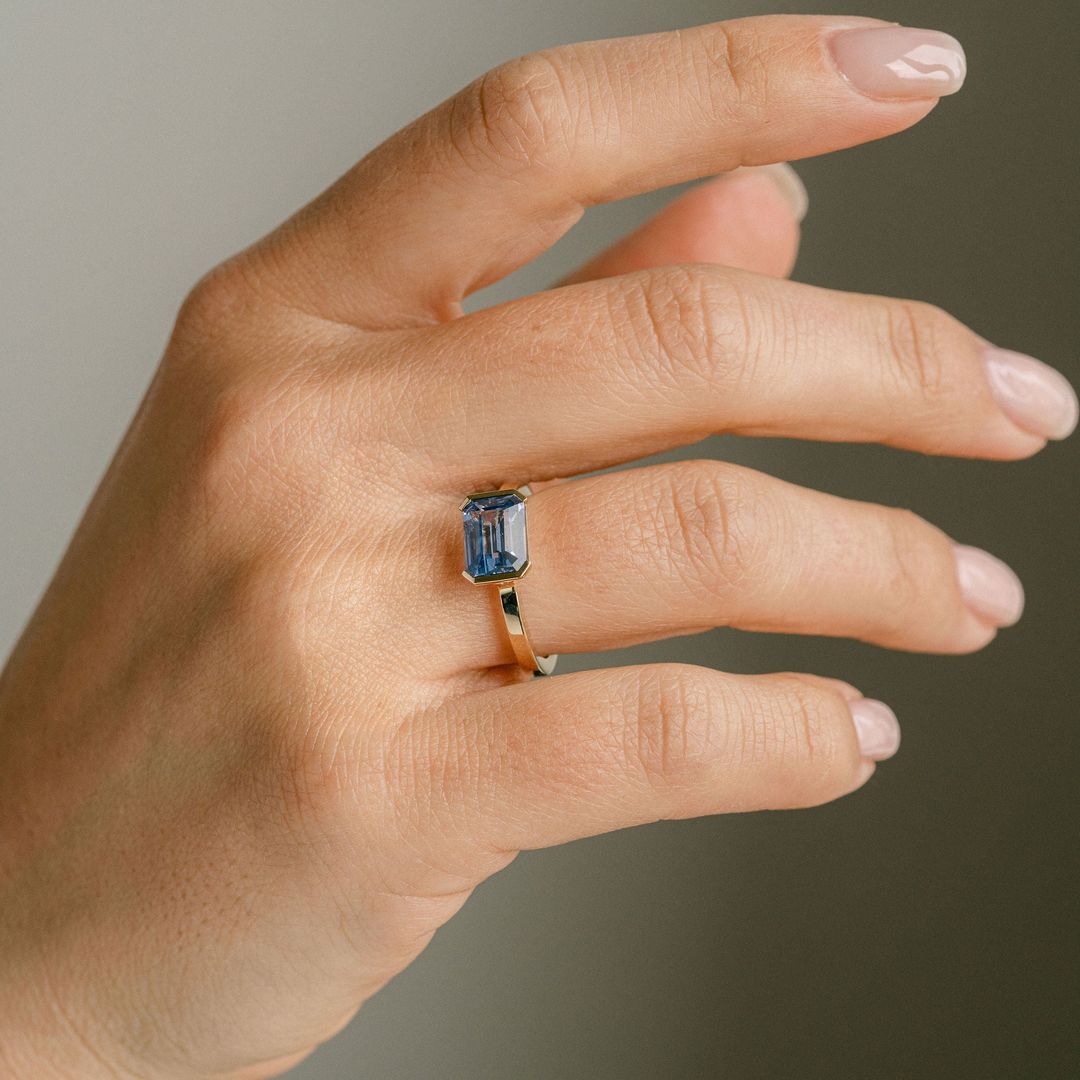 Emerald Cut Blue Sapphire East-West Half Bezel